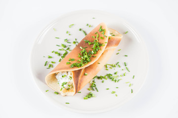 Pancake with cottage cheese and chives decorated with basil