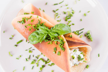 Pancake with cottage cheese and chives decorated with basil