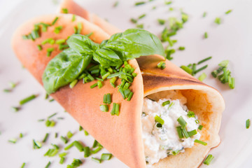 Pancake with cottage cheese and chives decorated with basil