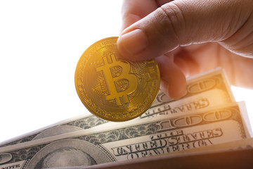 Hand holding Bitcoin or Cryptocurrency in brown leather wallet US Dollar. Bitcoins is modern of...