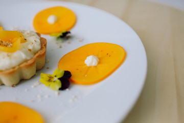 dessert tart with fruit, cream, plum, flowers, mint, almonds