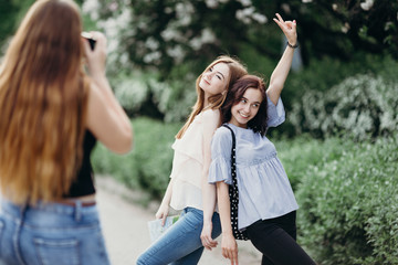 Photographing, hobby, leisure, traveling, friendship. Woman taking picture of her friends using camera