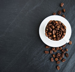 Naklejka premium Cup of coffee full of coffee beans