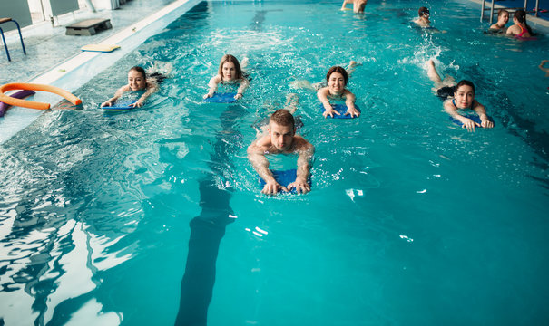 Male trainer swims with female aqua aerobics group