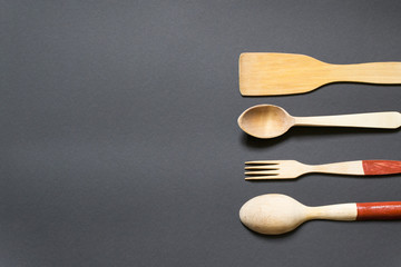 Wooden cutlery, cooking tools on a black background