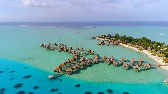 Aerial view of tropical paradise of Bora Bora island, turquoise crystal clear water of scenic blue lagoon, typical over water bungalows, Matira Point - South Pacific Ocean, French Polynesia from above