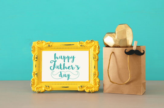 Image of shopping bag with gold heart, present for dad. Father's day concept.