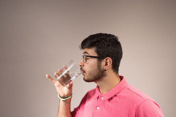 chico con gafas bebiendo agua
