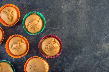 Homemade freshly made cupcakes in silicone molds on dark background. Top view. Concept of confectionery cooking