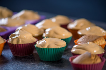 Homemade freshly made cupcakes in silicone molds on dark background. Concept of confectionery cooking