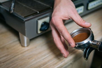Fototapeta na wymiar coffee brewing process. professional barista checking on pressed coffee powder in the holder
