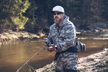 Naklejka premium Fishermen on the bank of a forest river