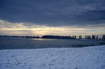 frozen lake in winter at sunset