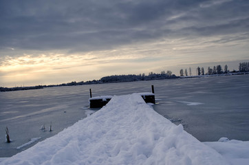 Fototapeta na wymiar lake pier at sunset in winter