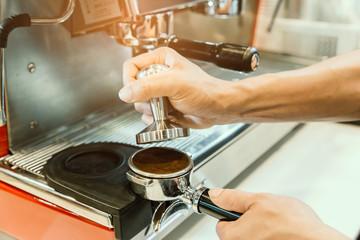 Barista prepare a coffee for extract in coffee machine with vintage tone.