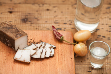 Fototapeta premium Pieces of salted lard, garlic, black pepper and onion on cutting board on wooden table. Top view