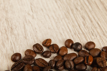 Grains of coffee on a wooden background in large quantities