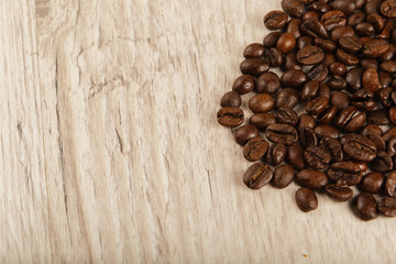 Grains of coffee on a wooden background in large quantities