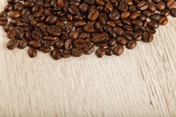 Grains of coffee on a wooden background in large quantities