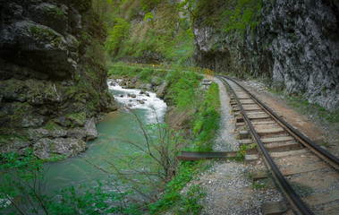 old narrow-gauge railroad under a rock near the mountain river in the gorge, the Guam gorge of...