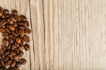 Grains of coffee on a wooden background in large quantities