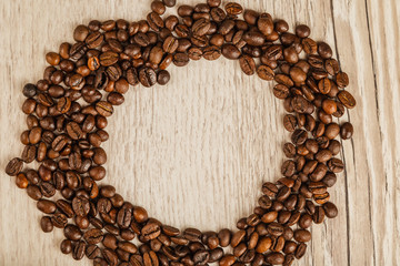 Grains of coffee on a wooden background in large quantities