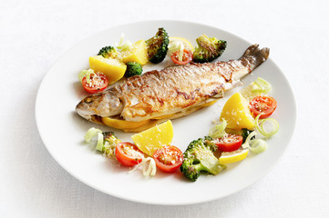 fried trout stuffed with lemon and leek served with vegetables and sprinkled with cheese