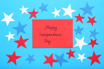 Paper stars and inscription Happy Independence Day on blue background
