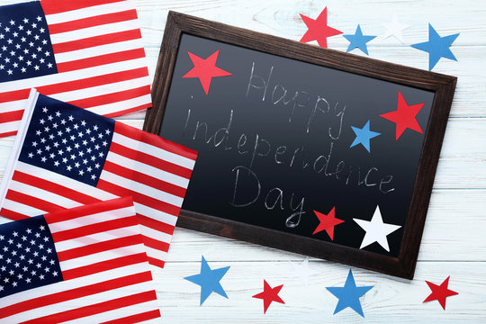 American flags and wooden frame with inscription Happy Independence Day