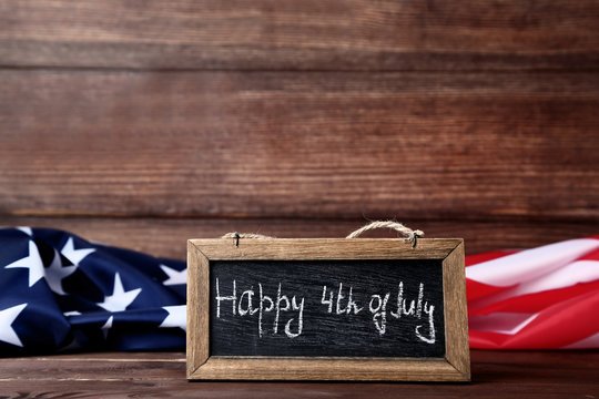 American flag and wooden frame with inscription Happy 4th of July
