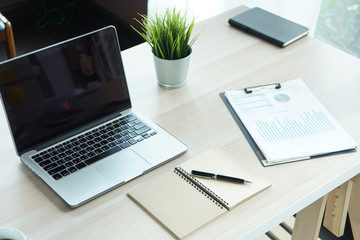 Top view desk of work table in office with laptop computer , notebook , calculator and a cup of coffee for creative business work or marketing plan to success planning of company