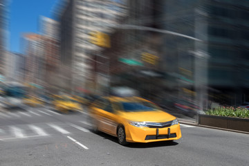 Fototapeta na wymiar New York City yellow taxi cab speeding through the streets of Manhattan with motion blur effect