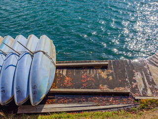 Row boats for rent and parking orderly off working hour on wooden deck.