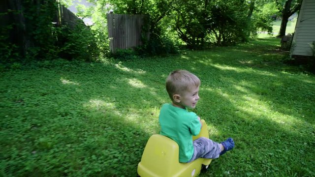 the little boy playing in the playground slides down from a hill 4k