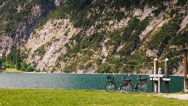 Bicycles on alpine lake in background mountains. Touring bicycle  with the beautiful view of mountain lake. Advertising banner for cycling.