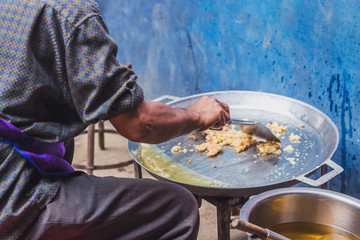 Close up at Cooking in thai food :Fried mussel pancakes or Oyster omelette (Hoi Tod) for students in school. Selective focus on hands.