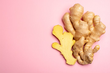Trendy food flat lay concept on light pink background with fresh big ginger root close up copy...