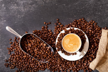 cup of coffee and coffee beans in a sack, top view