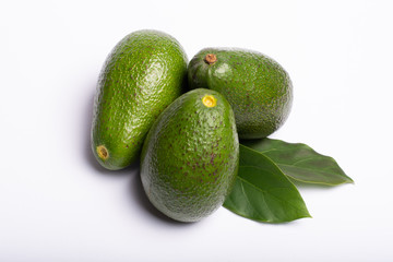 Fresh organic ripe green Fuerte avocado with leaves, copy space close up isolated on white background
