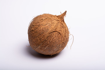One big brown whole coconut close up copy space isolated on white background