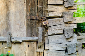 Authentic wooden door and a vintage lock on a rusty loop, copy space, concept of old objects