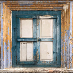 A closed and old wooden window of a building located in Perak, Malaysia.