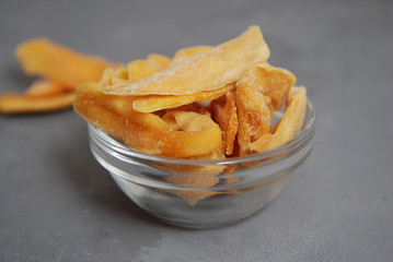 Healthy Snack. Dried Mango Chips in Glass Bowl. Gray Background with Gray Background.