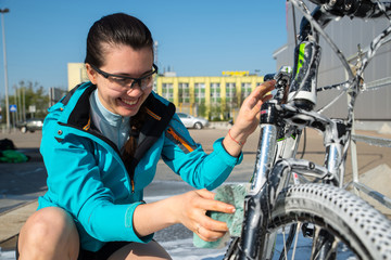 Fototapeta na wymiar young sport woman washing bicycle at self-service car wash