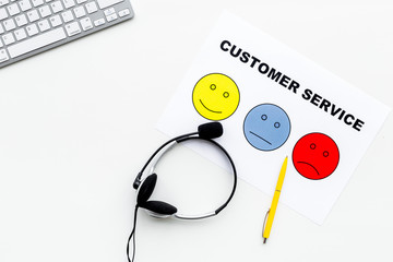 Customer service concept. Headphones on office desk. Signs for assessment of customer service quality on white background top view copy space