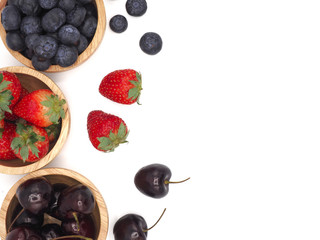 Fresh summer fruits, Cherry, strawberry, and blueberry in wooden bowl isolated on white background.