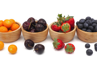 Fresh summer fruits, Cherry, strawberry, cape gooseberry and blueberry in wooden bowl isolated on white background.
