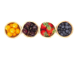 Fresh summer fruits, Cherry, strawberry, cape gooseberry and blueberry in wooden bowl isolated on white background.