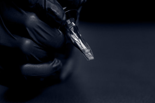 Woman master holding tattoo machine, preparing for drawing picture