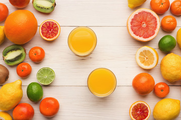 Assorted citrus fruits on white wooden planks, top view